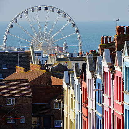Photograph of colourful terraced houses in Kemptown in Brighton, UK.  Shows the ferris wheel from Brighton breach in the background.